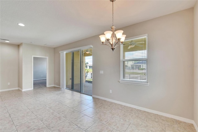 tiled empty room featuring a chandelier