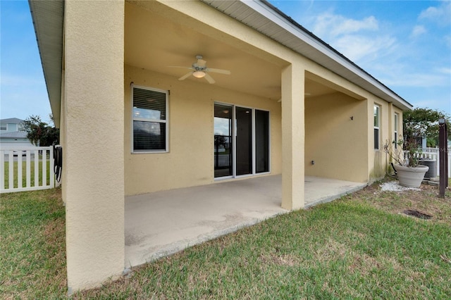 back of property featuring ceiling fan, a yard, and a patio