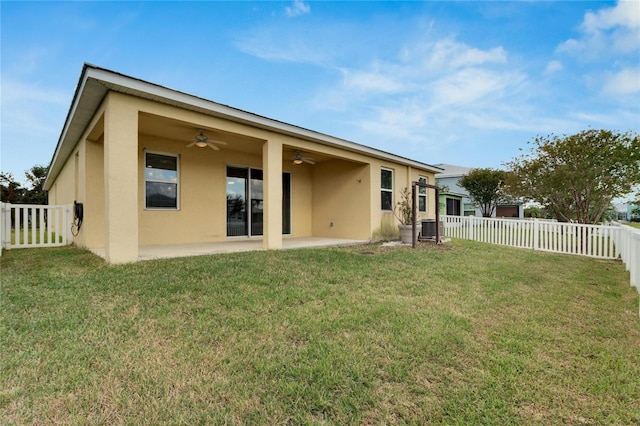 rear view of house featuring ceiling fan, a yard, and a patio