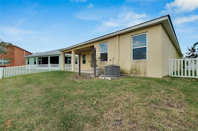 back of house featuring a yard and central AC unit