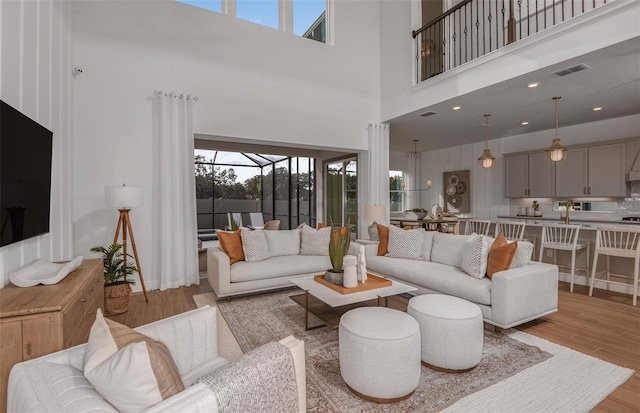 living room with a high ceiling and light hardwood / wood-style floors