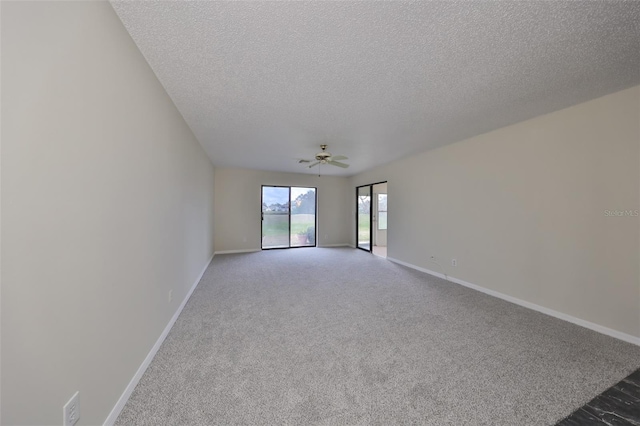 carpeted empty room with ceiling fan and a textured ceiling