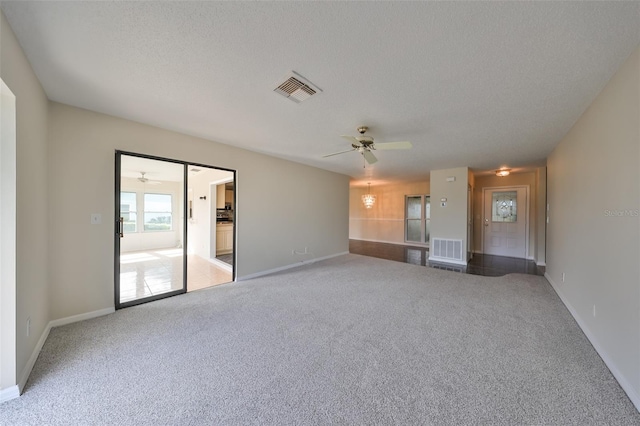 unfurnished living room with a textured ceiling, carpet floors, and ceiling fan