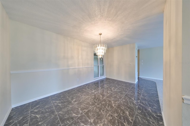 unfurnished room with a textured ceiling and a notable chandelier