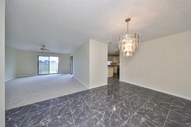 spare room with ceiling fan with notable chandelier and a textured ceiling