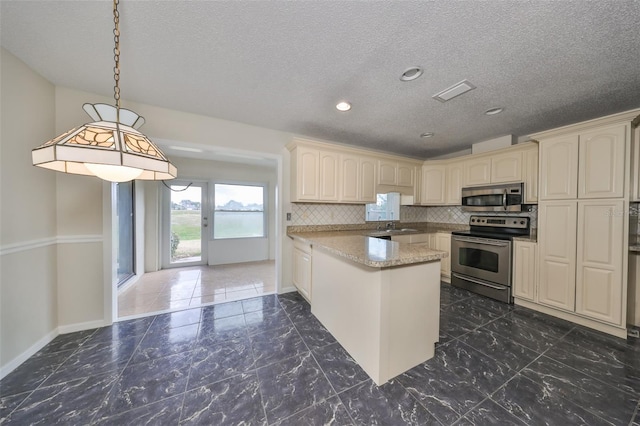 kitchen featuring kitchen peninsula, appliances with stainless steel finishes, tasteful backsplash, sink, and hanging light fixtures