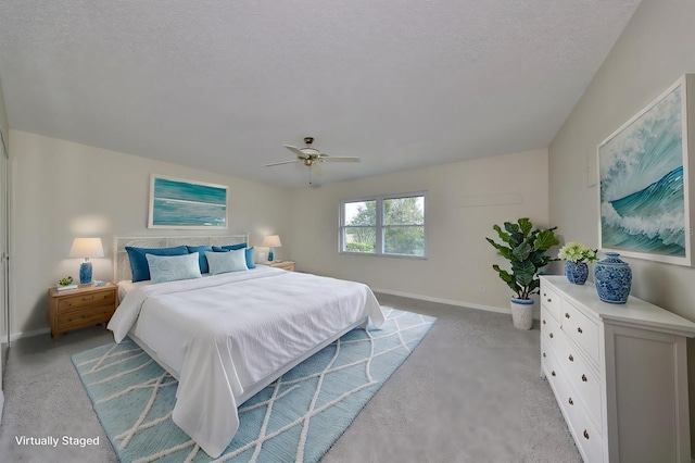 carpeted bedroom featuring ceiling fan and a textured ceiling