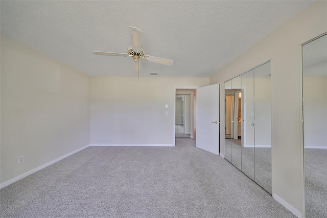 carpeted spare room with a textured ceiling and ceiling fan