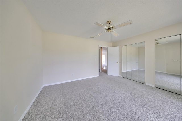 unfurnished bedroom with carpet flooring, ceiling fan, and two closets