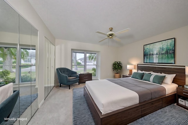 bedroom featuring carpet floors, ceiling fan, and multiple closets