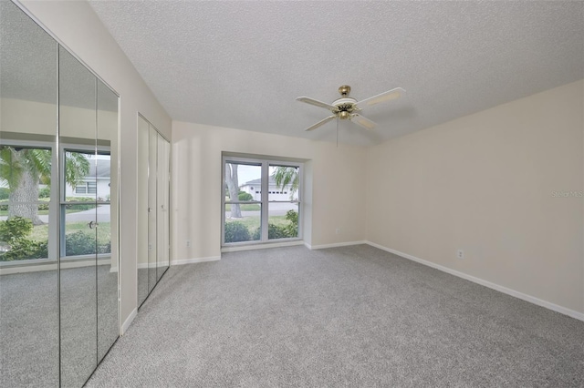 unfurnished room featuring ceiling fan, light carpet, and a textured ceiling