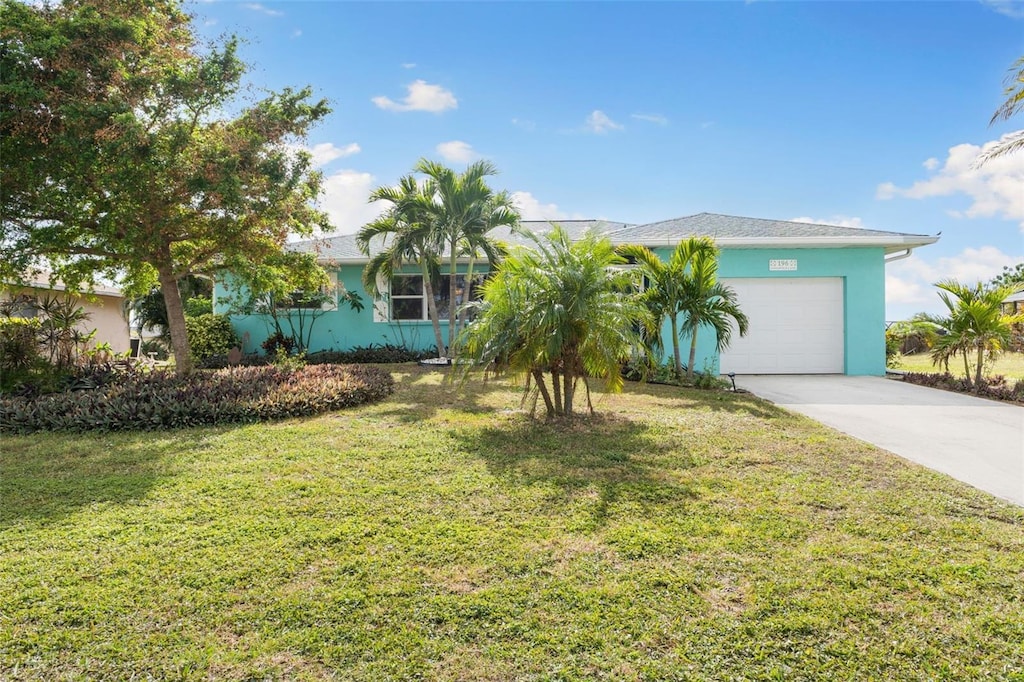 view of front of home with a garage and a front lawn