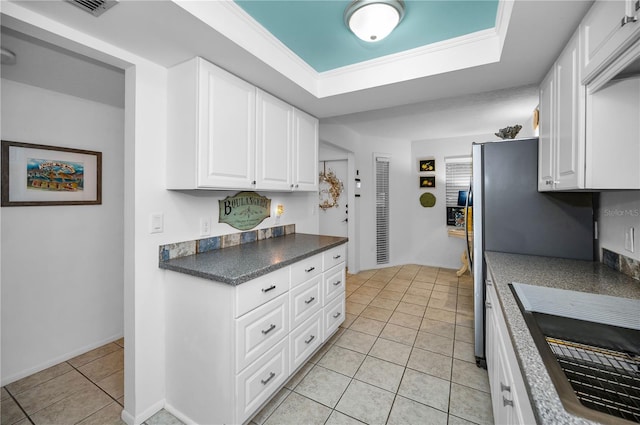 kitchen with white cabinetry, crown molding, and light tile patterned flooring