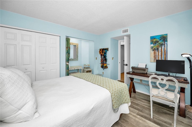 bedroom featuring hardwood / wood-style floors, a closet, and a textured ceiling