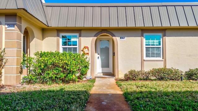 doorway to property with a lawn