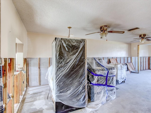 interior space with a textured ceiling and ceiling fan