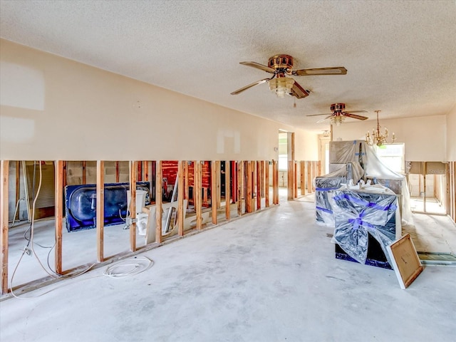 miscellaneous room featuring ceiling fan, concrete floors, and a textured ceiling