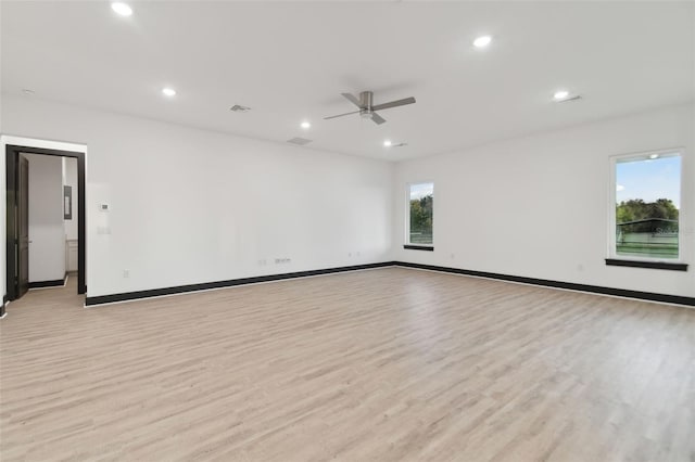 empty room with ceiling fan and light hardwood / wood-style floors