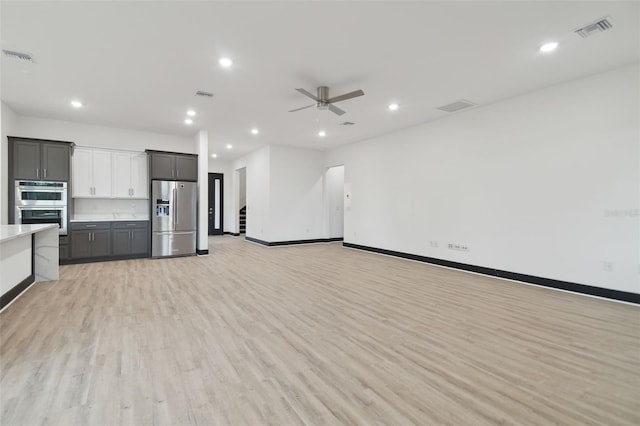 kitchen with ceiling fan, gray cabinets, appliances with stainless steel finishes, and light hardwood / wood-style flooring