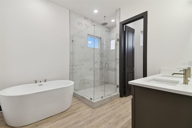 bathroom with vanity, hardwood / wood-style flooring, and independent shower and bath