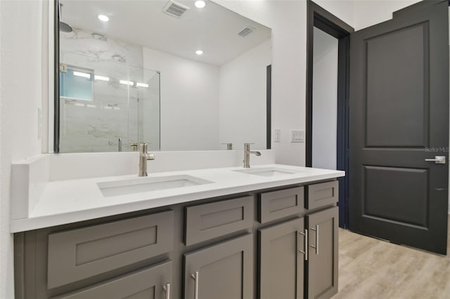 bathroom featuring wood-type flooring, vanity, and walk in shower