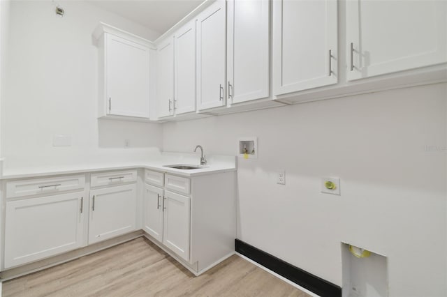 laundry area with sink, cabinets, hookup for an electric dryer, light hardwood / wood-style flooring, and hookup for a washing machine