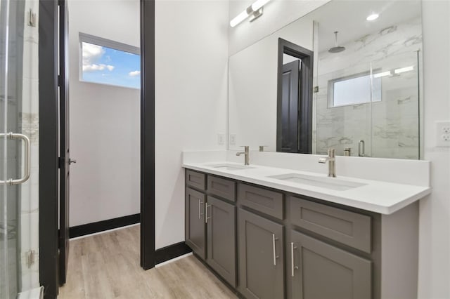 bathroom featuring hardwood / wood-style flooring, vanity, and an enclosed shower