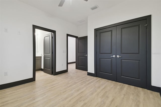 unfurnished bedroom with a closet, light hardwood / wood-style floors, ensuite bath, and ceiling fan