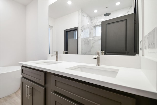 bathroom with hardwood / wood-style flooring, vanity, and shower with separate bathtub