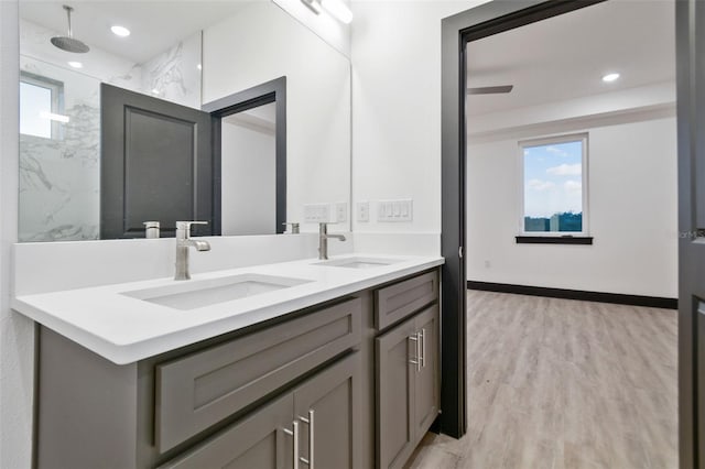 bathroom featuring hardwood / wood-style floors, vanity, ceiling fan, and tiled shower