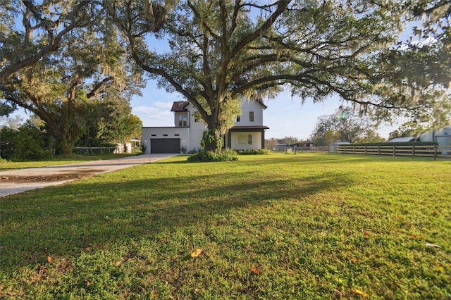 view of front facade featuring a front yard, a rural view, and a garage