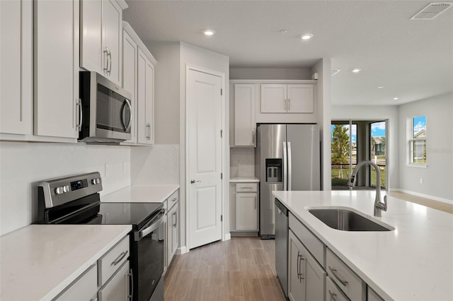 kitchen with stainless steel appliances, sink, and light wood-type flooring