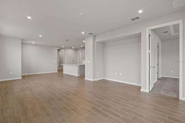 unfurnished living room featuring sink