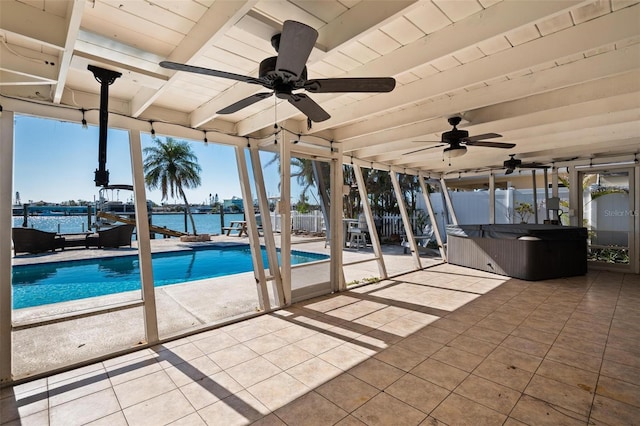 exterior space featuring a patio, a water view, and a hot tub