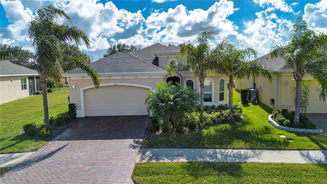 view of front of property with central AC, a front lawn, and a garage