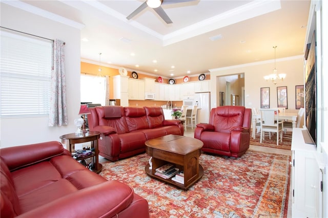 living room with crown molding, sink, and ceiling fan with notable chandelier