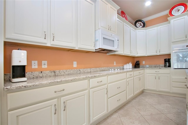 kitchen featuring white appliances, white cabinetry, ornamental molding, and light stone counters