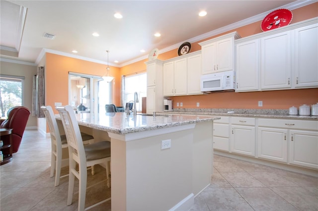 kitchen featuring crown molding, sink, white cabinetry, and a kitchen island with sink