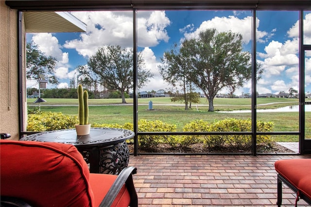 sunroom featuring a water view