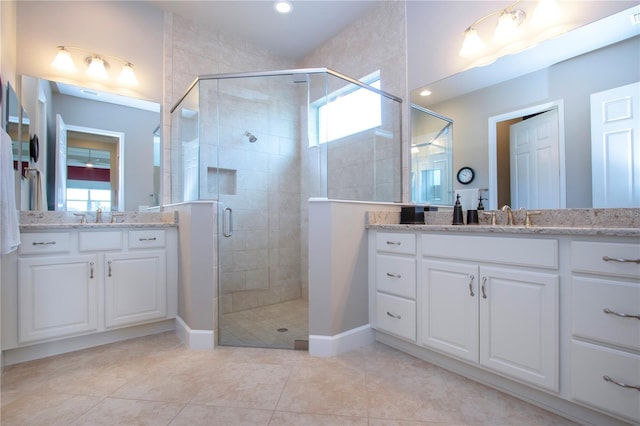 bathroom featuring tile patterned floors, plenty of natural light, a shower with door, and vanity