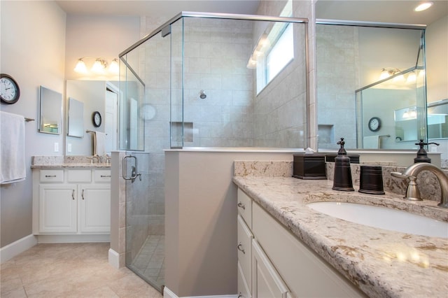 bathroom with tile patterned flooring, vanity, and walk in shower