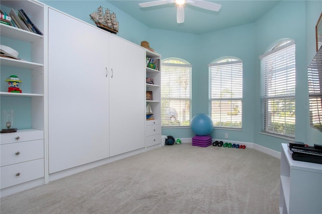 interior space featuring light colored carpet, a wealth of natural light, and ceiling fan