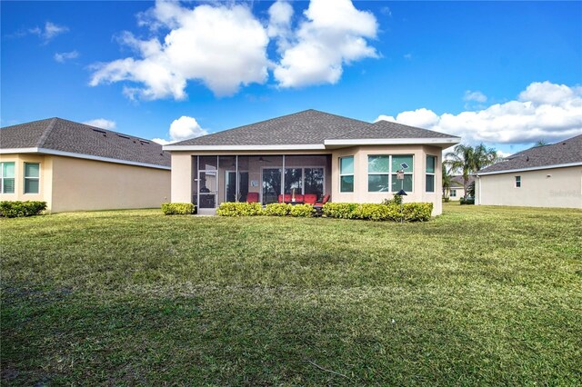 rear view of house with a sunroom and a yard