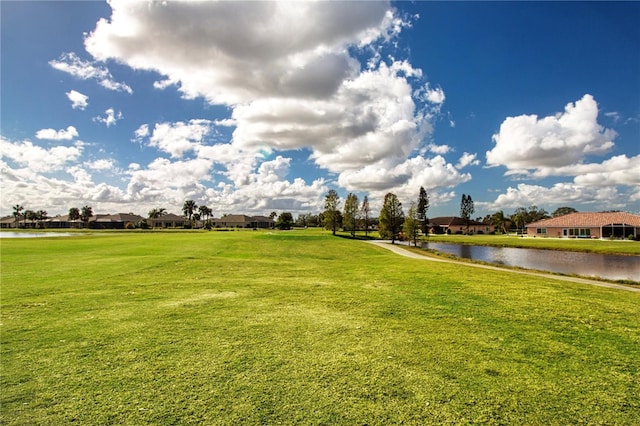 view of home's community with a lawn and a water view