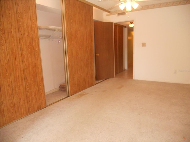 unfurnished bedroom featuring light carpet, a closet, and ceiling fan