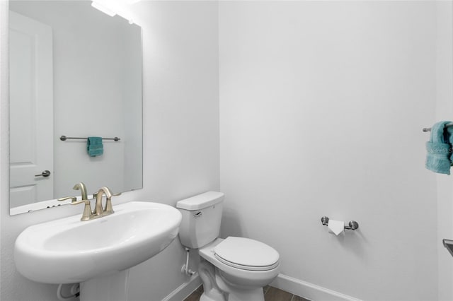 bathroom with wood-type flooring, sink, and toilet