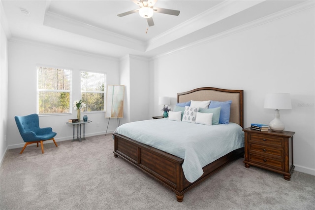 bedroom with light carpet, a tray ceiling, and ornamental molding