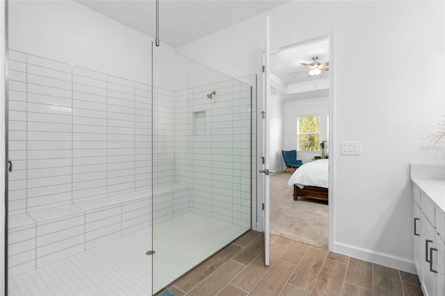 bathroom with ornamental molding, vanity, ceiling fan, and tiled shower