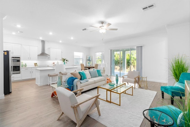 living room with light hardwood / wood-style flooring and ceiling fan