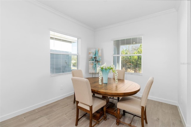 dining space featuring ornamental molding and light hardwood / wood-style flooring